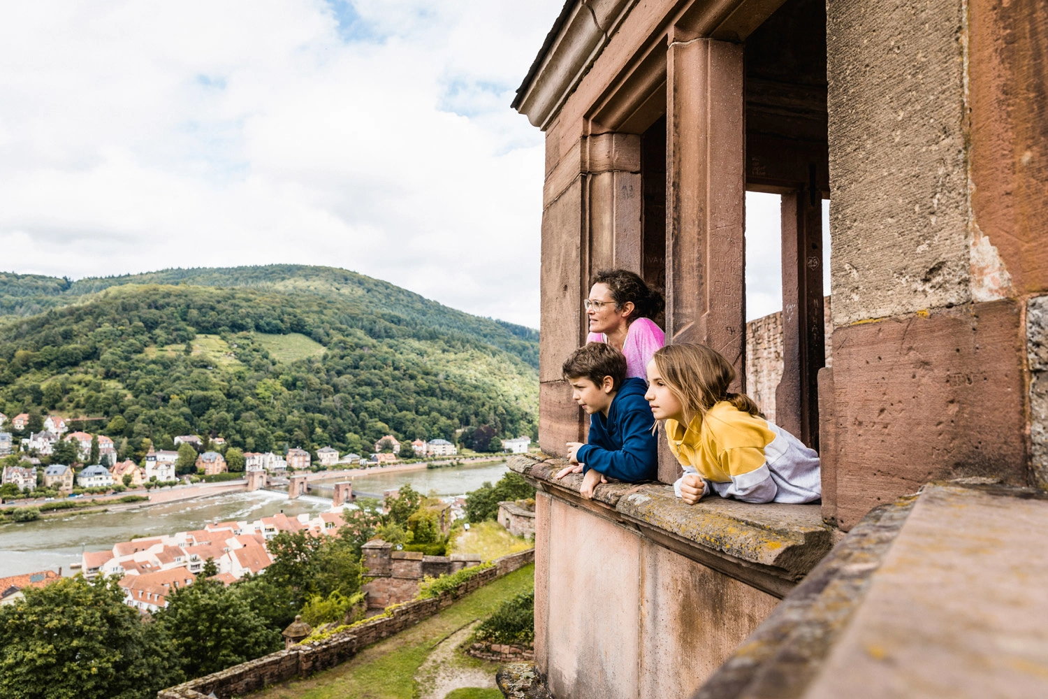Mutter, Sohn und Tochter genießen den Ausblick von einem Schloss.