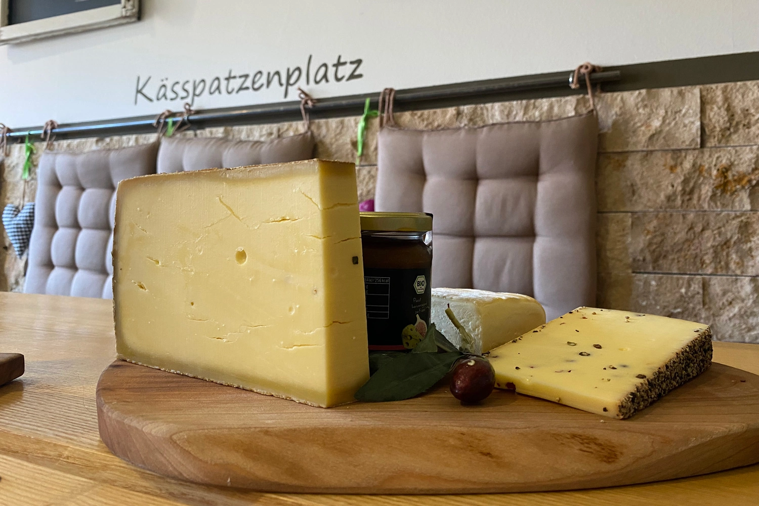 Auf einem Holzbrett liegen verschiedene Käsesorten.