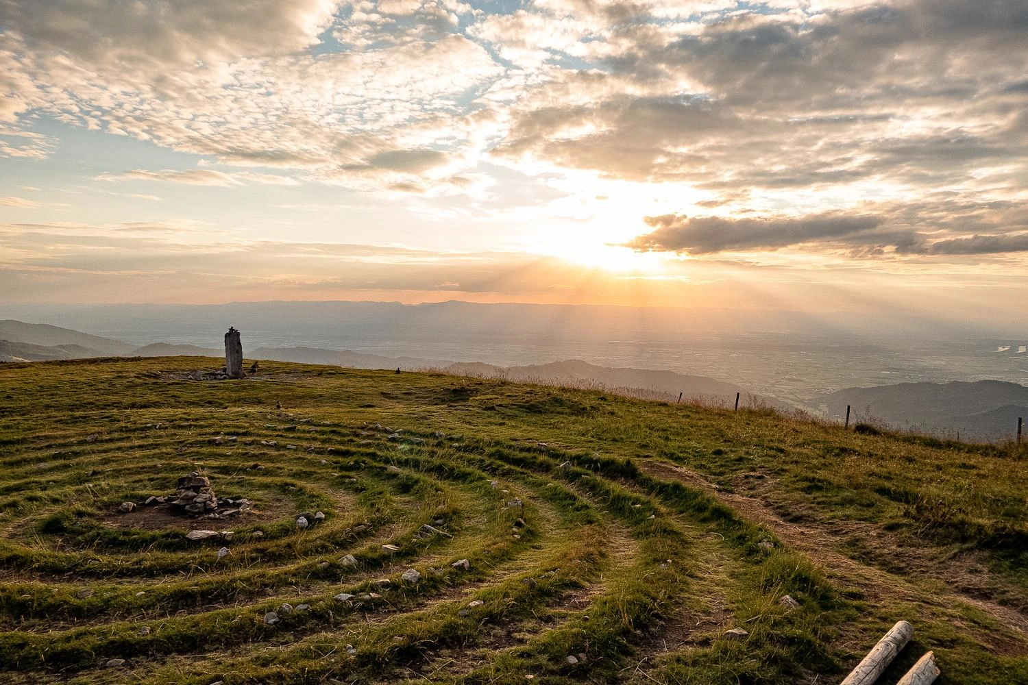 Blick vom einem Berg in ein weitläufiges Tal bei Sonnenuntergang