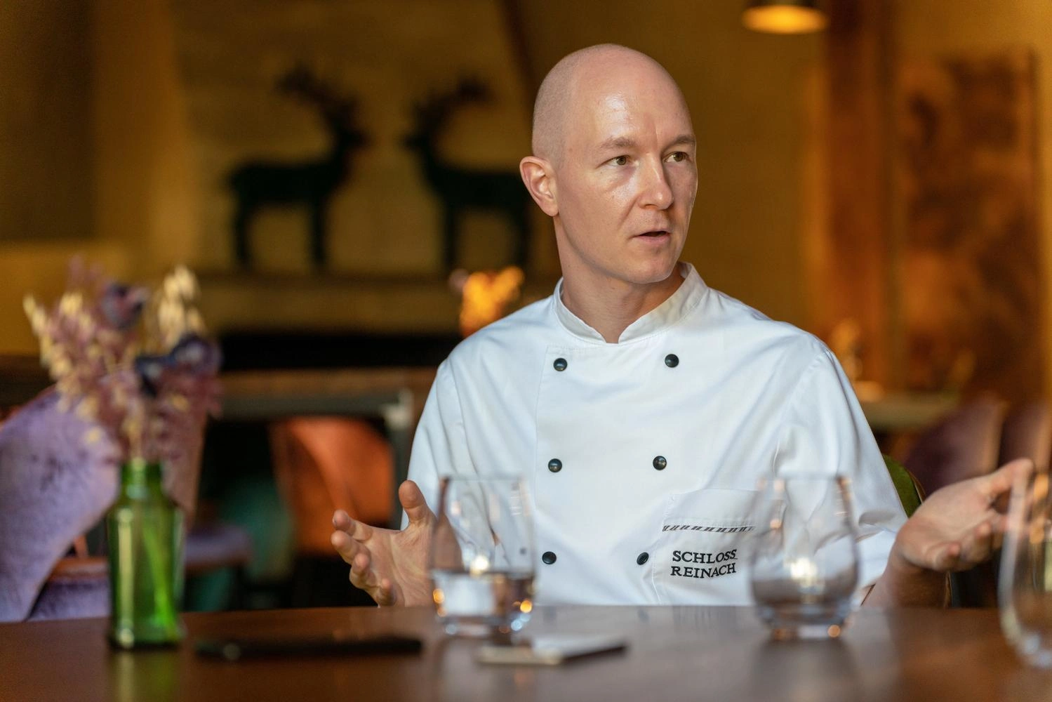  A man in a chef's jacket gives an interview.