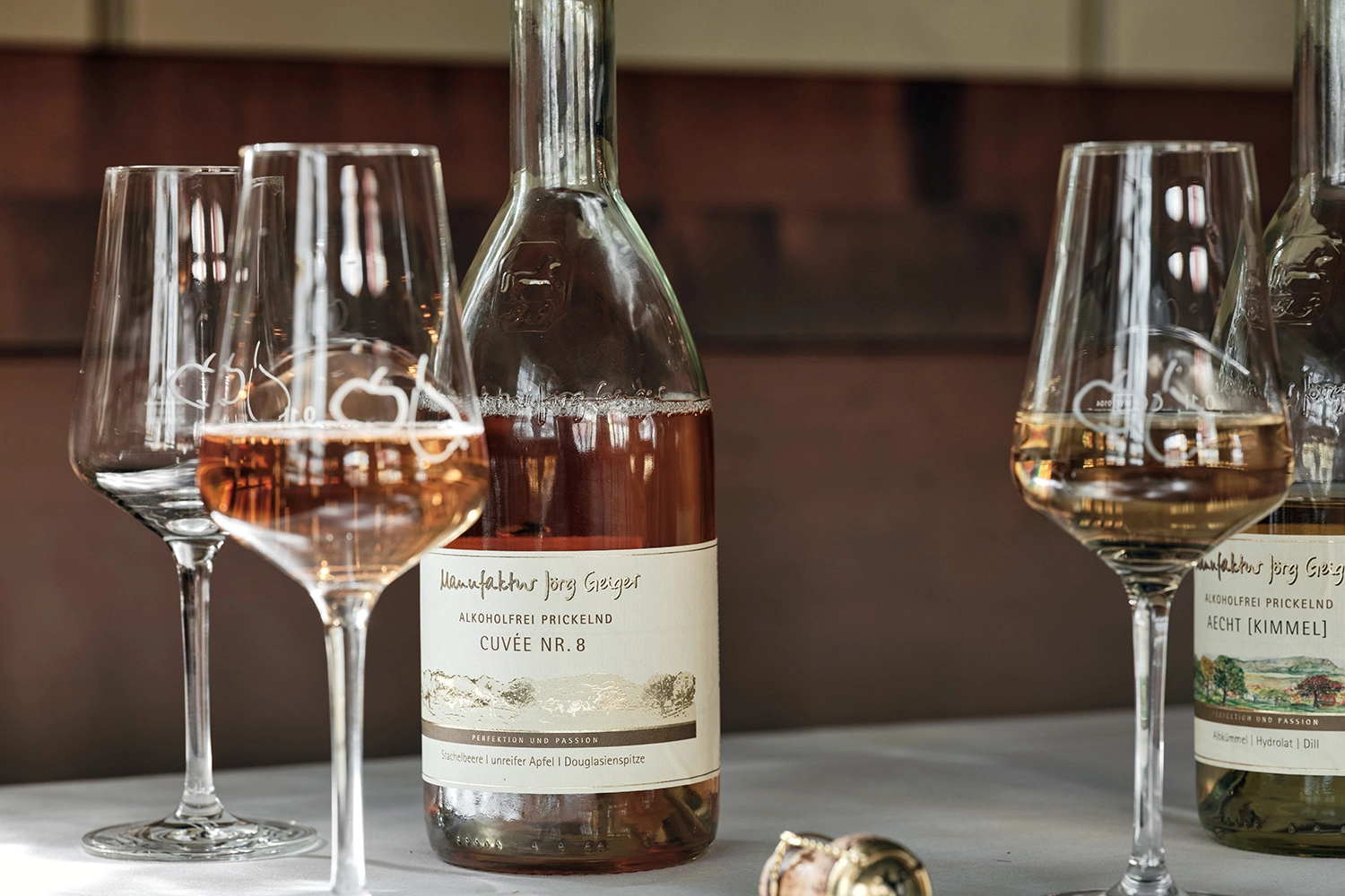 Glasses and a bottle of PriSecco Cuvee No. 8 from Manufaktur Jörg Geiger stand on a table