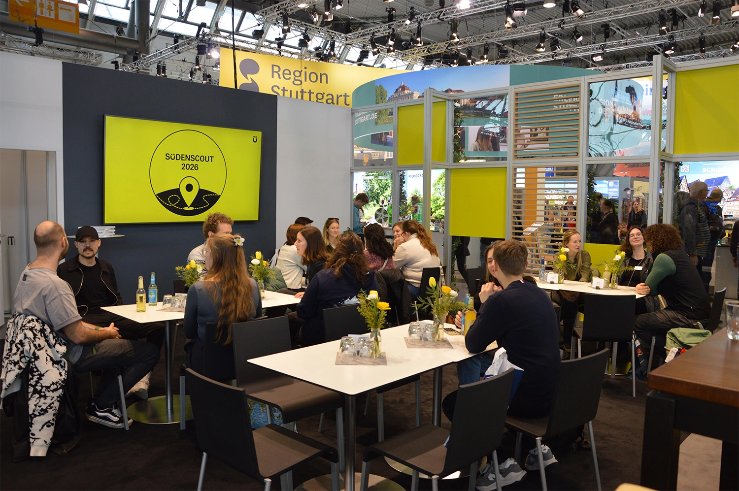 Auf dem Messestand der TMBW sitzen mehrere Personen an Tischen und tauschen sich im Rahmen des „Sudenscout 2026“-Events aus.