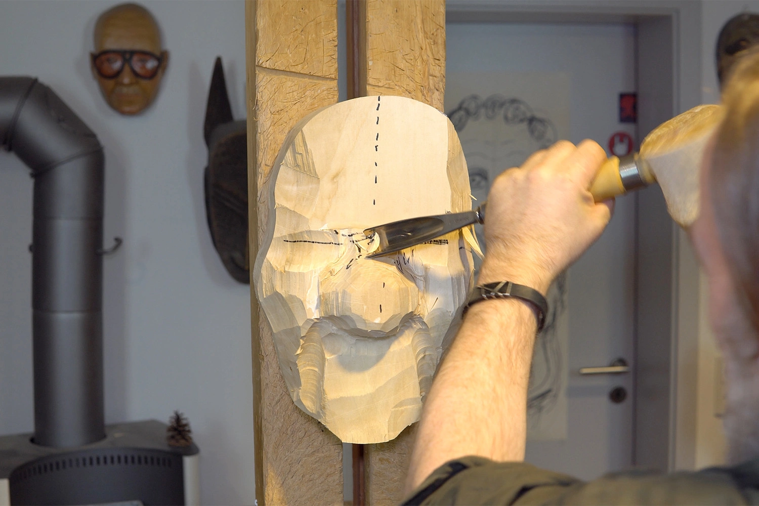 The rough mask structure is hewn onto the wooden block.