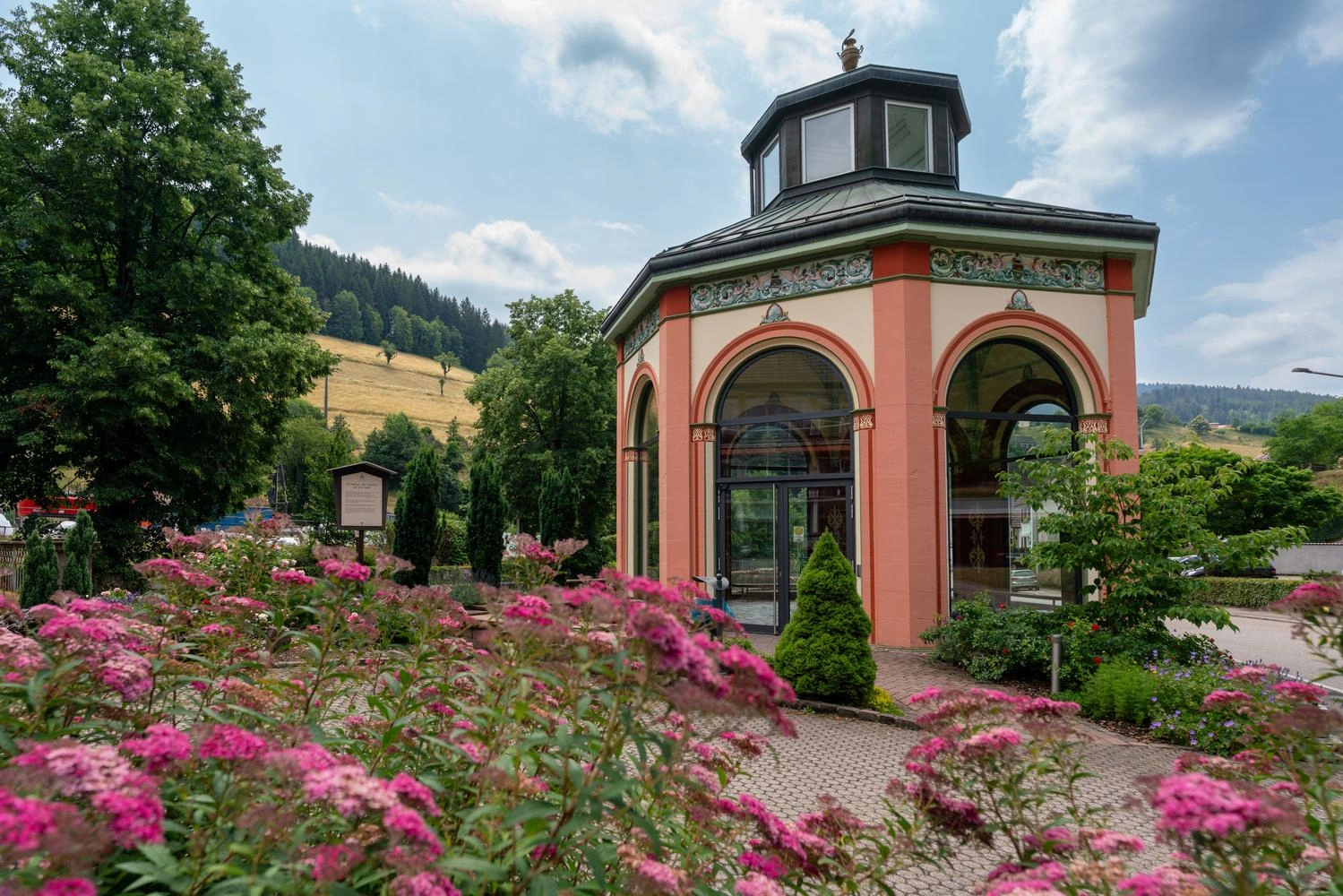 Ein gut einsehbarer Tempel mit Glasbögen in dem eine Quelle entspringt.