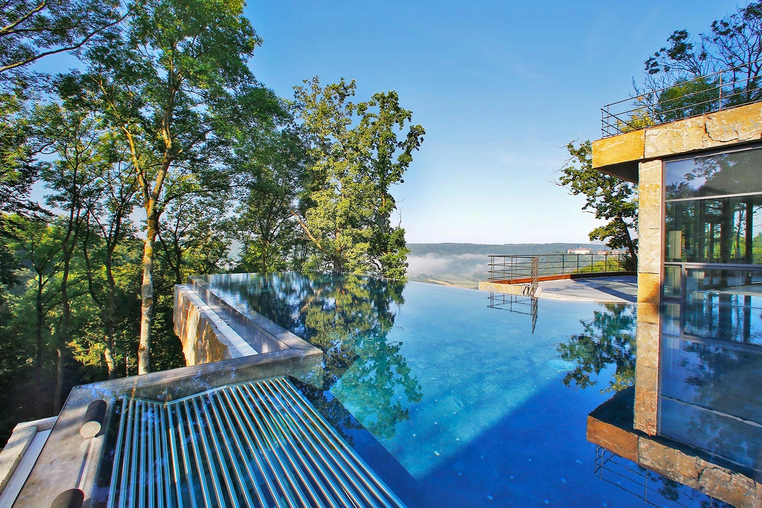 Infinity pool at Maxwell Resort with a view of nature.