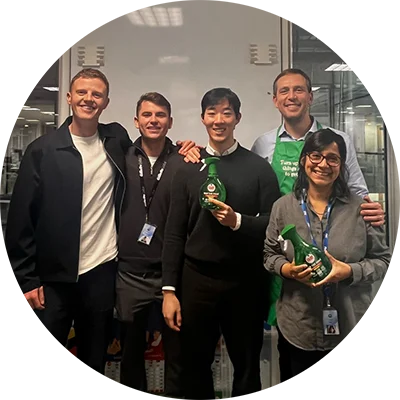 Group photo of five colleagues smiling and holding bottles of Fairy Skip The Soak bottles.