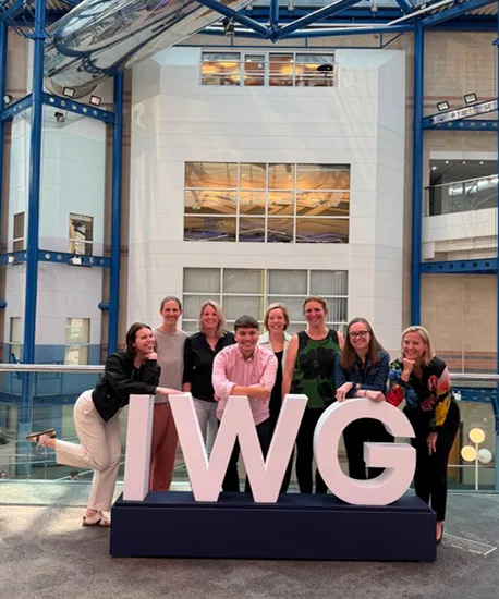 P&G delegates pose beside large IWG letters at the IWG Women & Sport Summit in Birmingham.