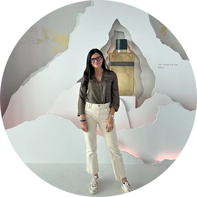 Woman standing in front of a Pantene display featuring a large cut-out mountain design and the text “Born in Switzerland