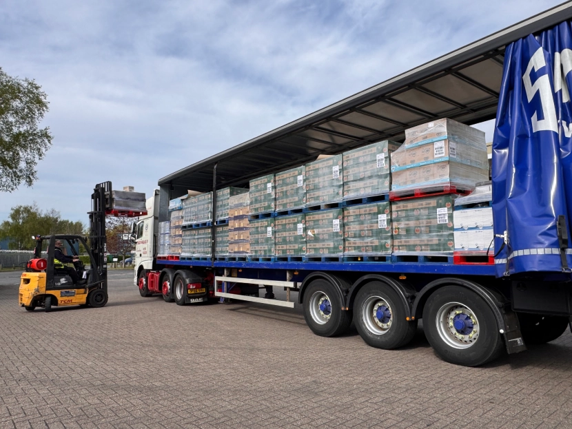 Forklift unloading pallets from a truck, showcasing efficient logistics and transportation operations in a commercial setting