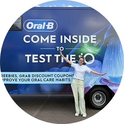 Visitor standing beside the Oral-B Brush for Better bus promoting oral health education and healthy brushing habits.