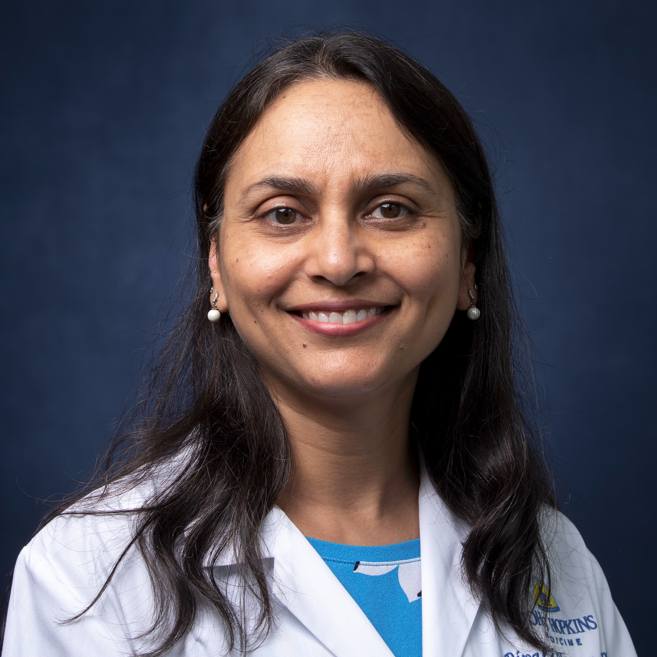 Headshot of Dr. Dipali Sharma wearing a white coat.
