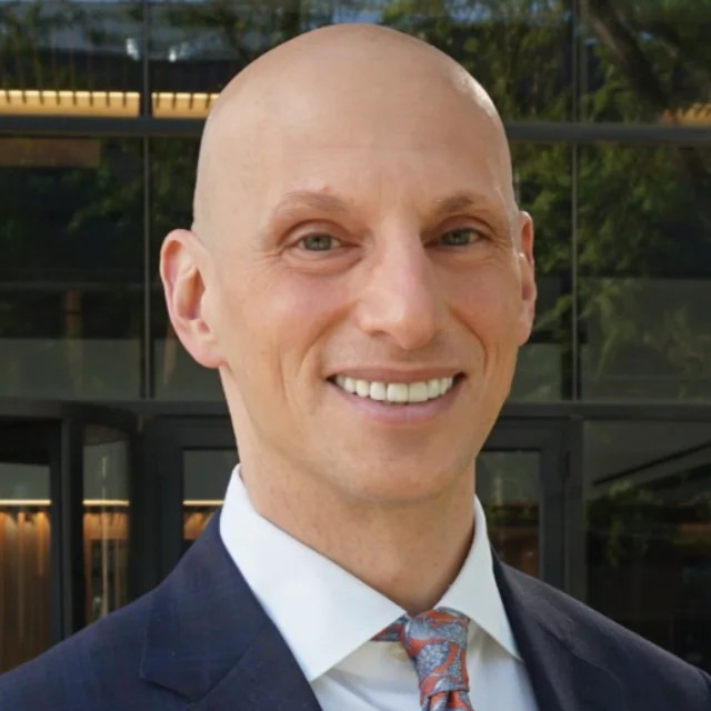 Head shot of Joseph Dayan, a white bald man.