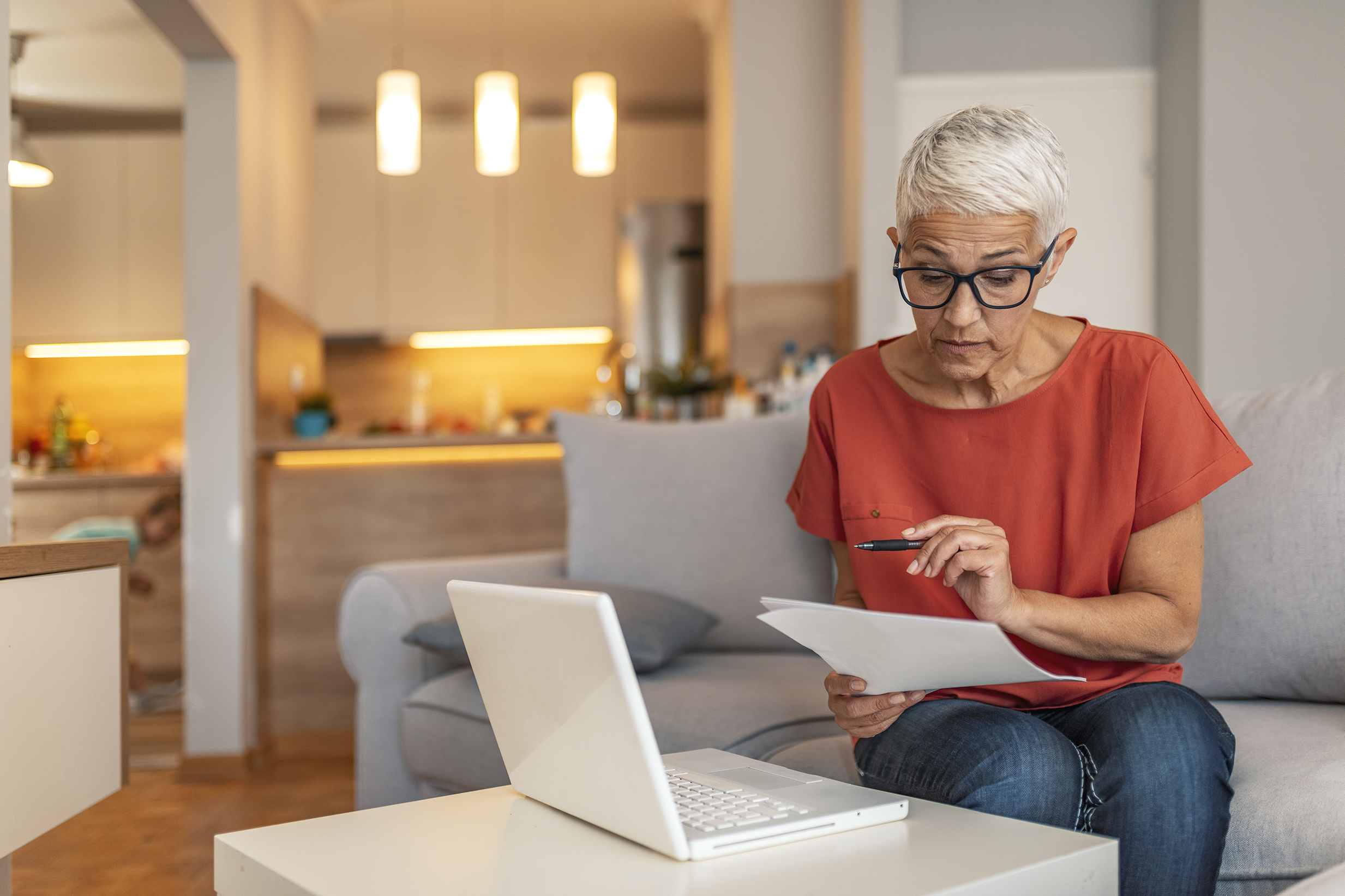 woman looking at papers and the computer